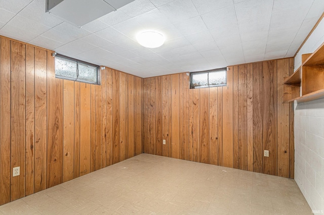 basement featuring wooden walls and tile patterned floors