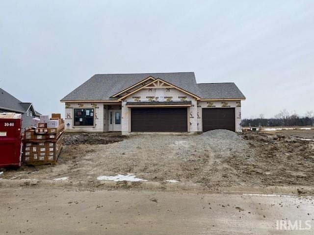 unfinished property featuring a garage and driveway