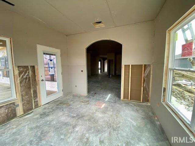 empty room featuring visible vents and arched walkways