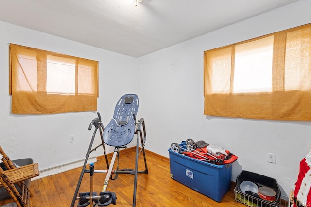 workout room featuring wood-type flooring and baseboards