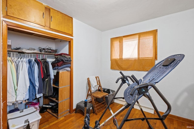 exercise room featuring wood finished floors and baseboards