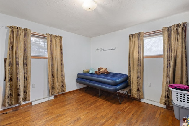 sitting room with hardwood / wood-style floors, visible vents, and a healthy amount of sunlight