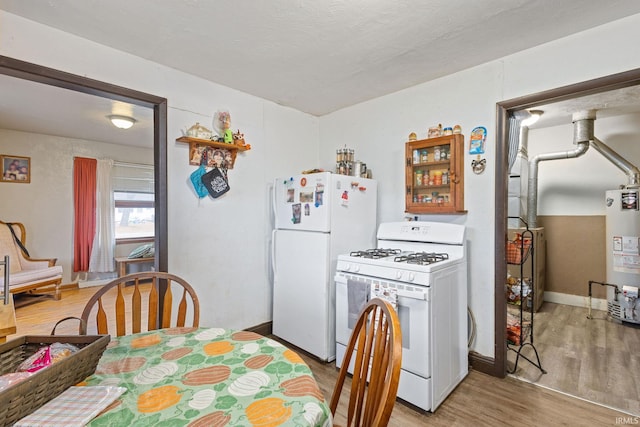 kitchen featuring a textured ceiling, gas water heater, white appliances, baseboards, and light wood-type flooring