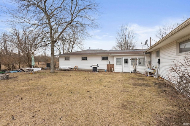 rear view of property with a yard