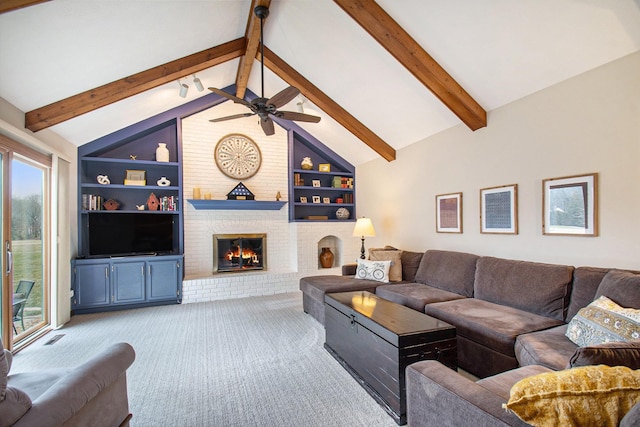 carpeted living room with built in shelves, a fireplace, visible vents, lofted ceiling with beams, and ceiling fan