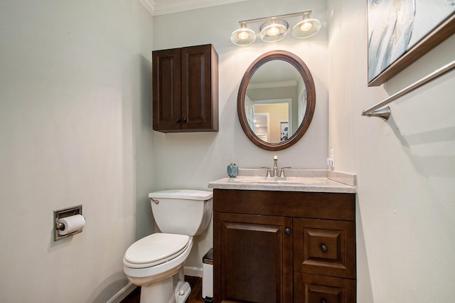 bathroom featuring toilet, ornamental molding, and vanity