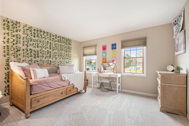 bedroom featuring light carpet, multiple windows, and baseboards