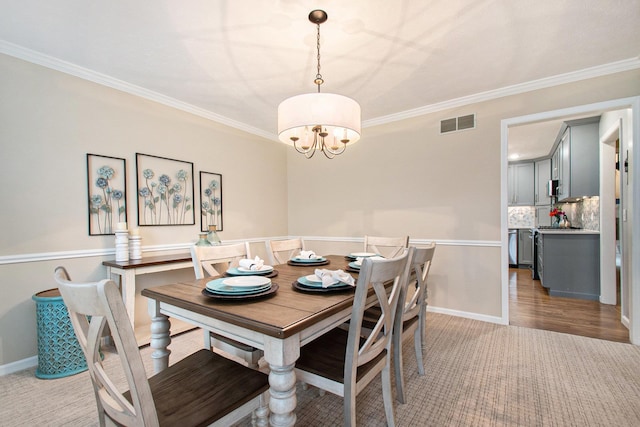 dining space with crown molding, baseboards, visible vents, and a notable chandelier