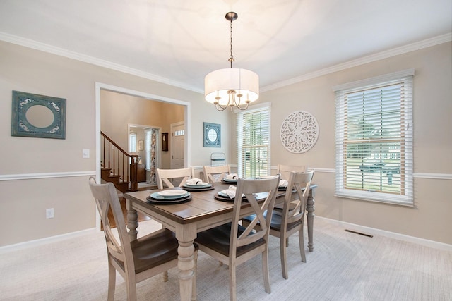 dining space featuring a notable chandelier, ornamental molding, visible vents, and baseboards