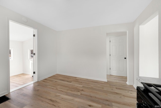 spare room with light wood-type flooring and baseboards