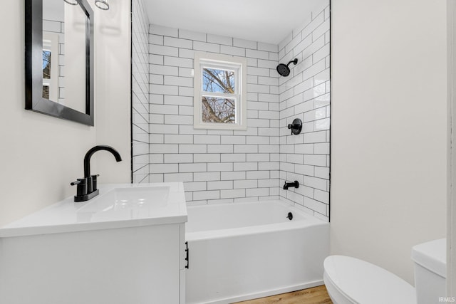 bathroom featuring toilet, shower / washtub combination, wood finished floors, and vanity