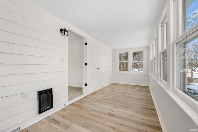 unfurnished sunroom featuring visible vents, a fireplace, and heating unit