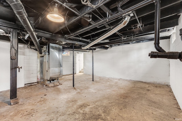 unfinished basement featuring heating unit