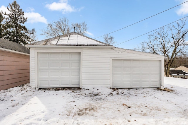 snow covered garage with a detached garage