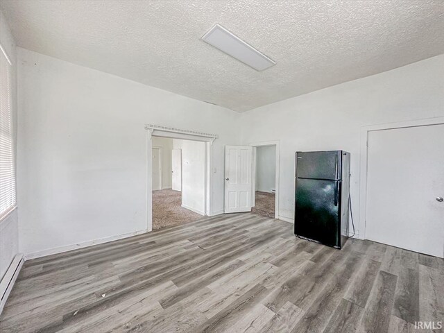 233 W 4th St, Greensburg, IN 47240 - unfurnished room with a textured ceiling, a baseboard heating unit, and wood finished floors