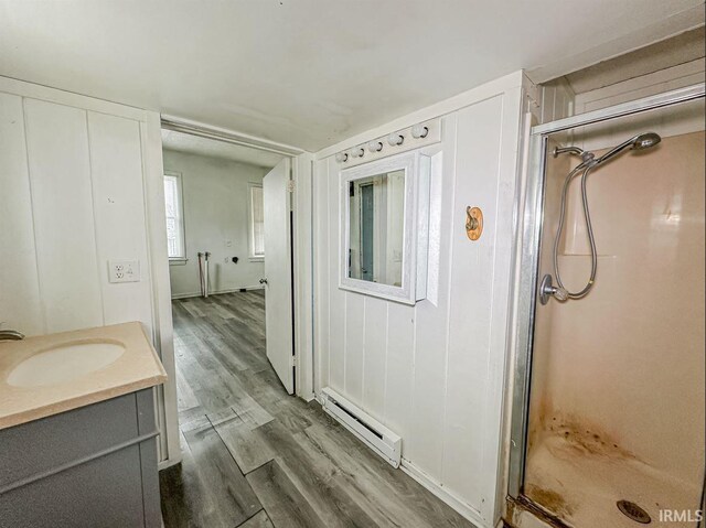 233 W 4th St, Greensburg, IN 47240 - full bathroom with a stall shower, a baseboard heating unit, wood finished floors, and vanity