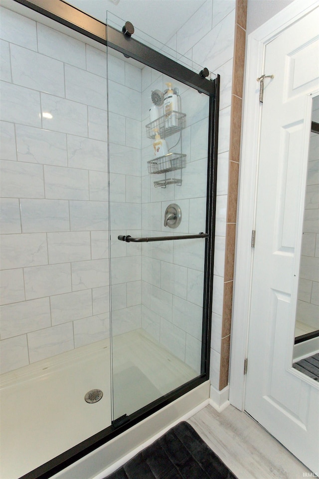 bathroom featuring a shower stall and wood finished floors