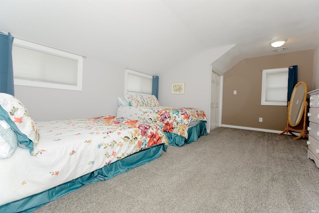 carpeted bedroom featuring lofted ceiling and baseboards