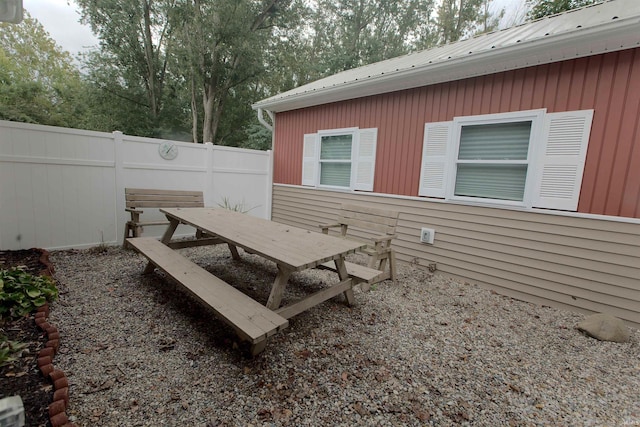 exterior space featuring outdoor dining area and fence