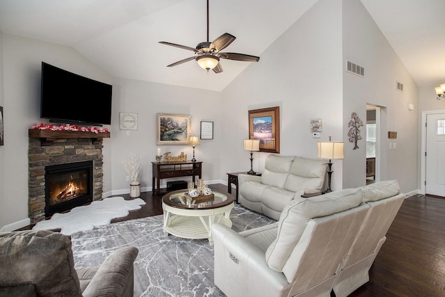 living room featuring baseboards, visible vents, ceiling fan, wood finished floors, and a stone fireplace