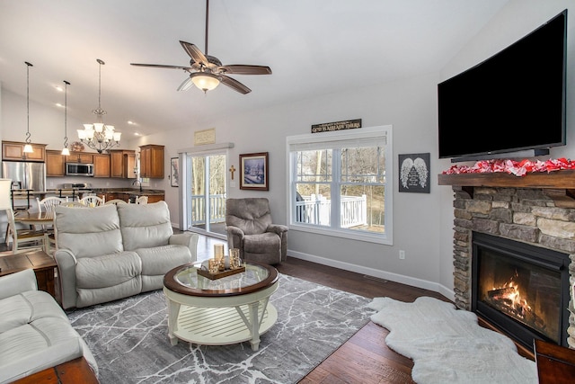 living area featuring dark wood-style flooring, a fireplace, visible vents, baseboards, and vaulted ceiling