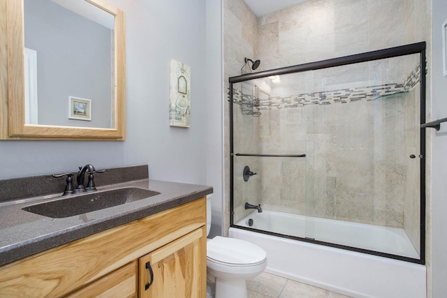 full bath with shower / bath combination with glass door, vanity, toilet, and tile patterned floors