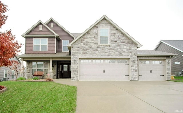 craftsman-style house with covered porch, an attached garage, a front yard, cooling unit, and driveway