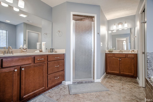 bathroom with baseboards, two vanities, a sink, and a shower stall