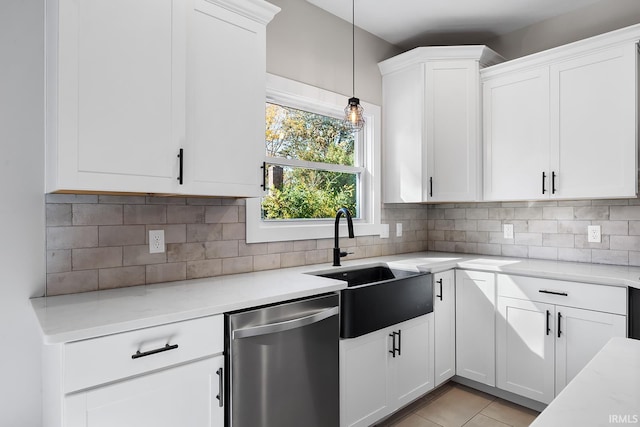 kitchen featuring stainless steel dishwasher, a sink, white cabinetry, and decorative backsplash