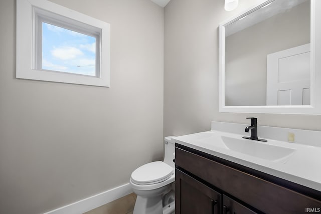 bathroom featuring toilet, tile patterned flooring, baseboards, and vanity