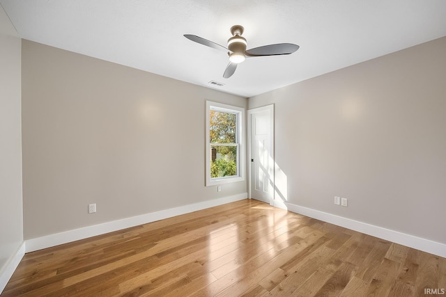 empty room featuring baseboards, a ceiling fan, visible vents, and light wood-style floors