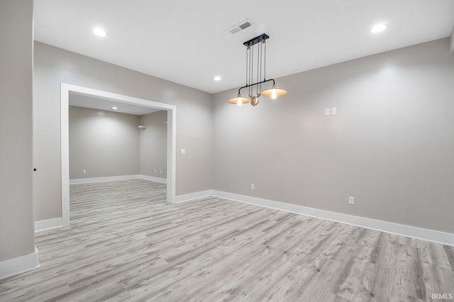 spare room featuring light wood finished floors, recessed lighting, visible vents, and baseboards