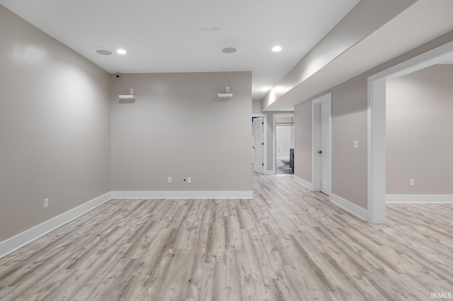 basement featuring light wood-type flooring, baseboards, and recessed lighting