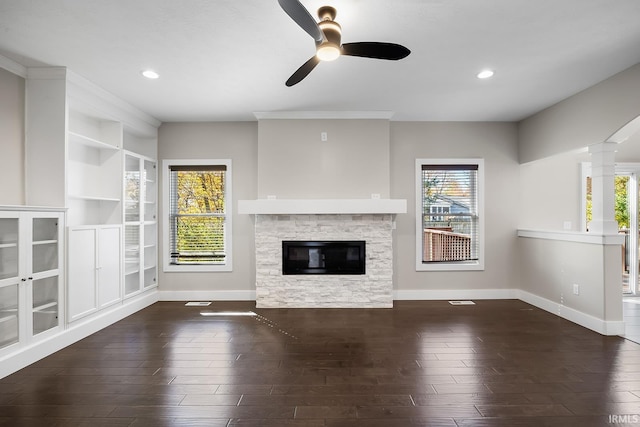 unfurnished living room with plenty of natural light, wood finished floors, and baseboards