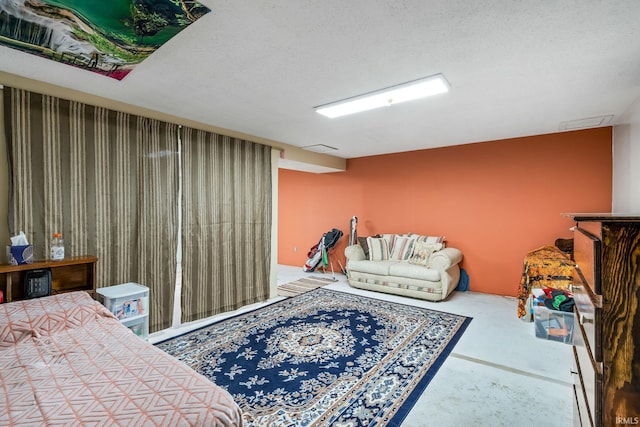 bedroom featuring concrete flooring, a textured ceiling, and visible vents