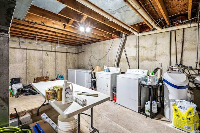 unfinished basement with fridge and separate washer and dryer