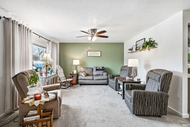 living room featuring a textured ceiling, ceiling fan, carpet, and baseboards