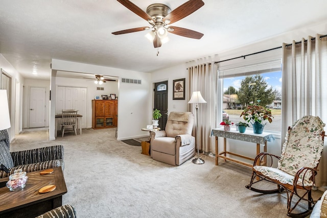 living area featuring carpet flooring, visible vents, and baseboards