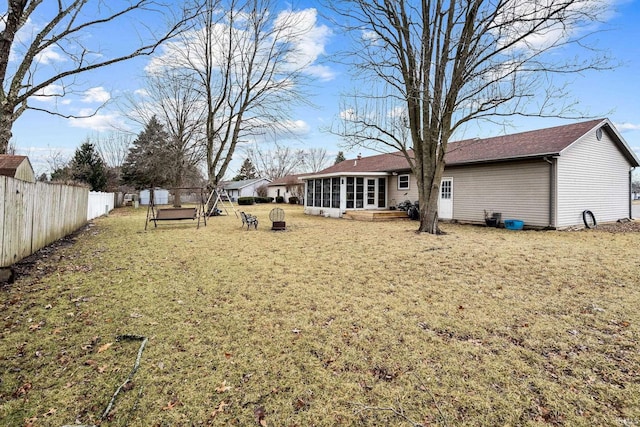 view of yard featuring a sunroom and fence