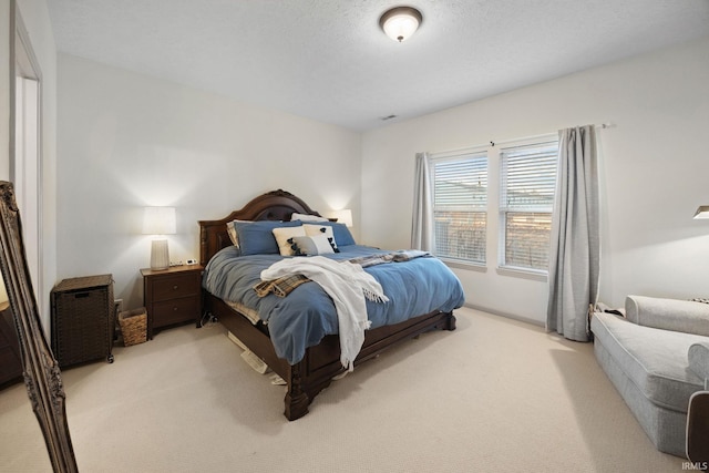 bedroom with light carpet, visible vents, and a textured ceiling