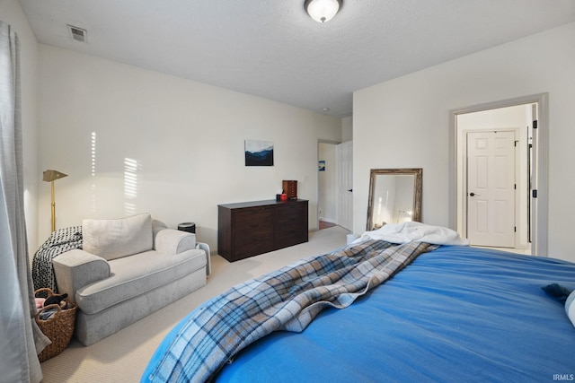 carpeted bedroom featuring visible vents and a textured ceiling