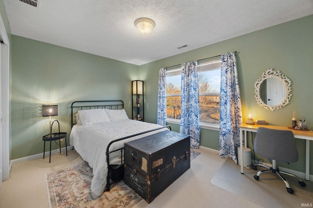 carpeted bedroom with a textured ceiling, visible vents, and baseboards