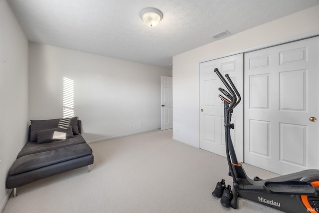 workout room with visible vents, a textured ceiling, and carpet flooring