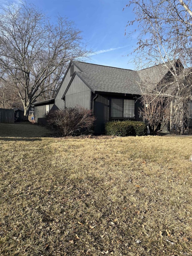 view of property exterior featuring a lawn and roof with shingles