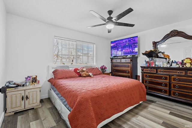 bedroom featuring ceiling fan, baseboards, and wood finished floors