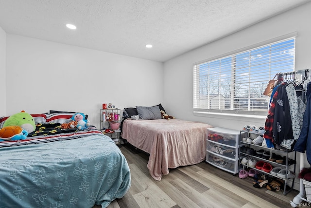 bedroom featuring a textured ceiling, wood finished floors, and recessed lighting