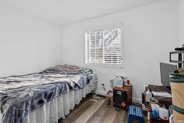 bedroom with baseboards and wood finished floors