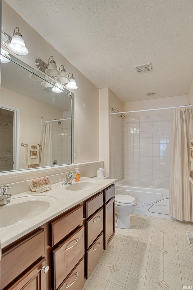 bathroom with shower / bath combination with curtain, visible vents, a sink, and a textured ceiling