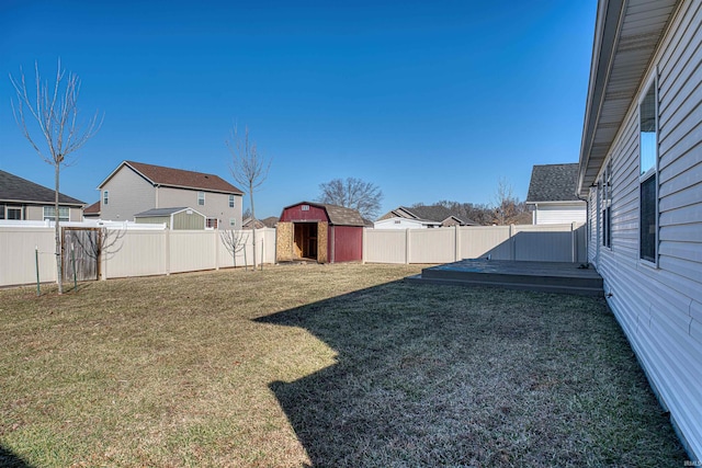 view of yard featuring an outbuilding, a deck, a fenced backyard, a residential view, and a shed