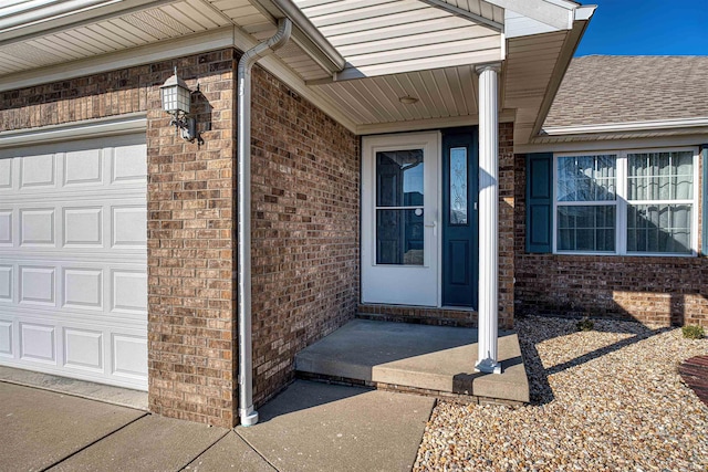 entrance to property featuring brick siding and an attached garage